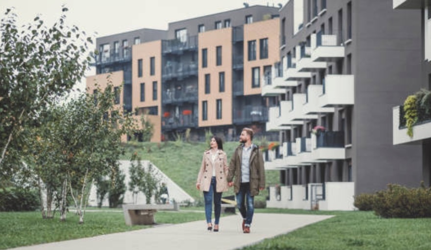 Two people walking outside of an apartment complex