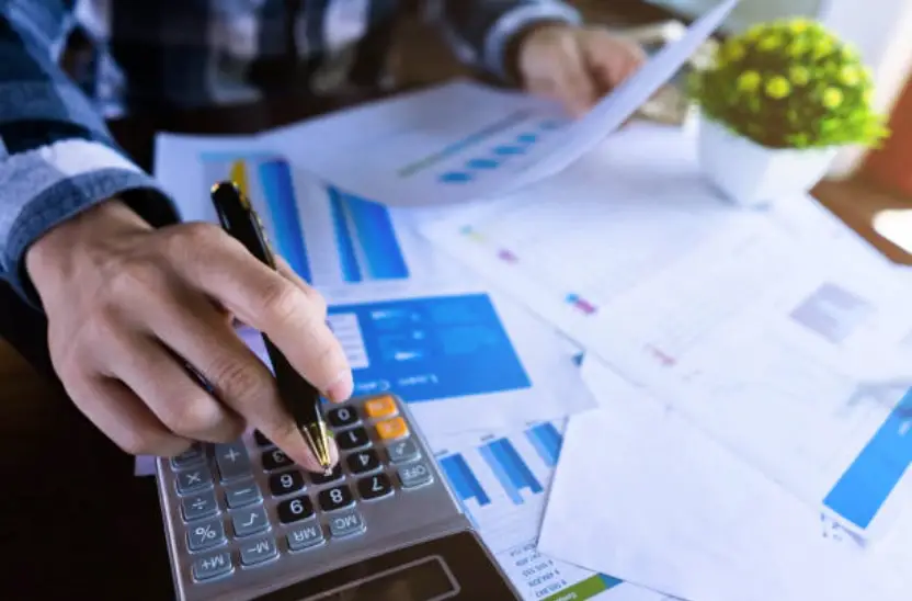 Hands holding a paper and using a calculator