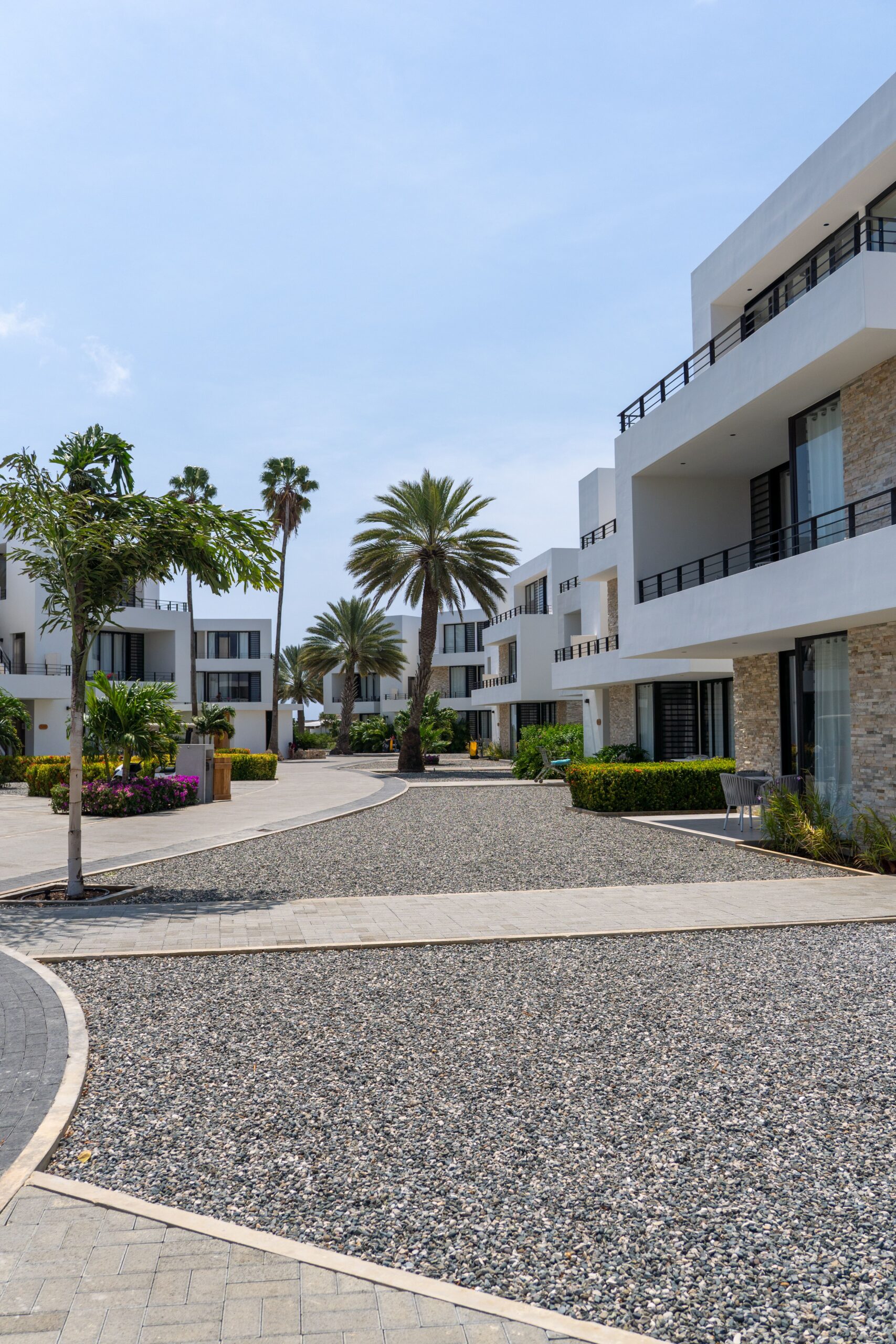 Luxurious apartment complex in Bonaire, showcasing tropical landscaping under a bright sky.